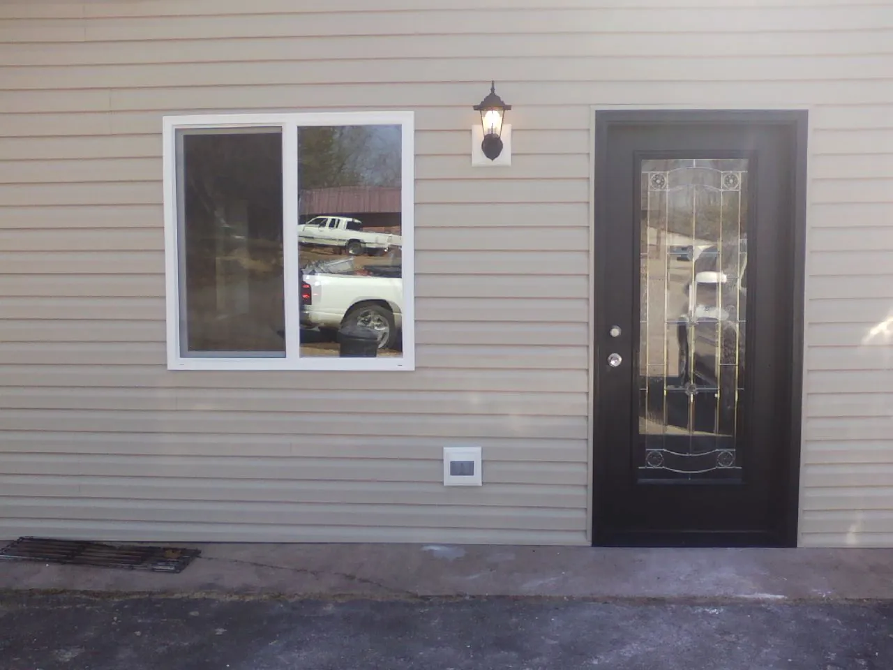 New siding, window and entry door on the side of an addition in Evergreen